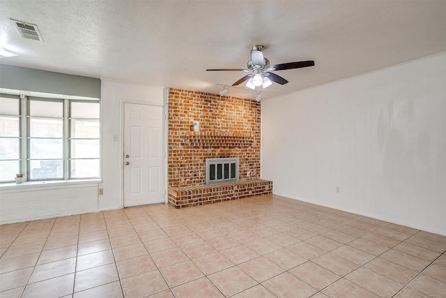 unfurnished living room with a brick fireplace, ceiling fan, a textured ceiling, and light tile patterned flooring