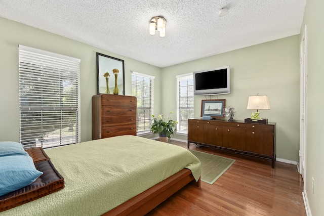 bedroom with hardwood / wood-style flooring and a textured ceiling