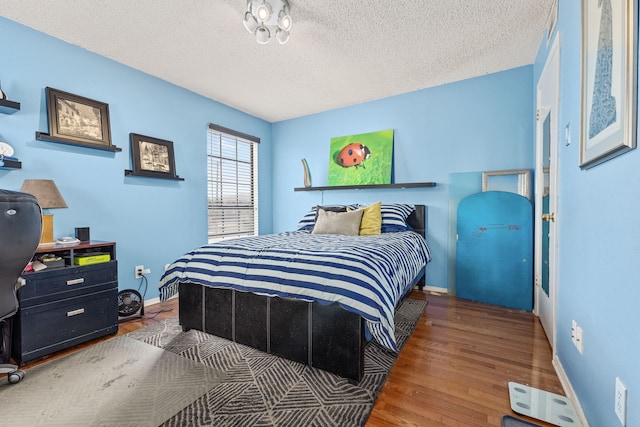 bedroom with dark hardwood / wood-style flooring and a textured ceiling