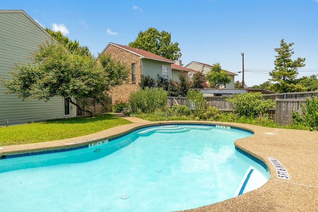 view of pool featuring a lawn