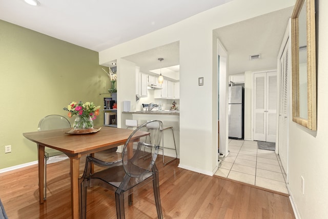 dining space with light wood-type flooring