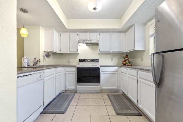 kitchen with white cabinetry, white appliances, a tray ceiling, and hanging light fixtures