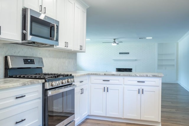 kitchen with decorative backsplash, appliances with stainless steel finishes, light stone counters, ceiling fan, and white cabinets