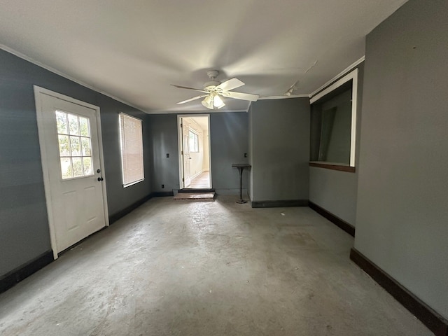 empty room featuring ceiling fan, concrete floors, and ornamental molding