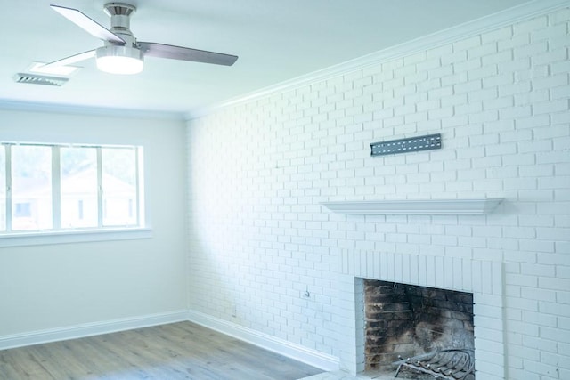 unfurnished living room featuring hardwood / wood-style flooring, a brick fireplace, crown molding, and brick wall