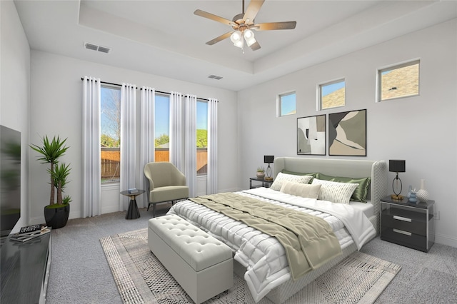 bedroom featuring ceiling fan, light carpet, and a tray ceiling