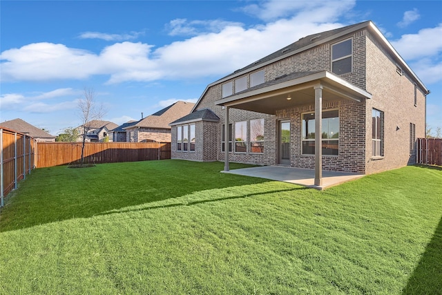 rear view of house featuring a lawn and a patio