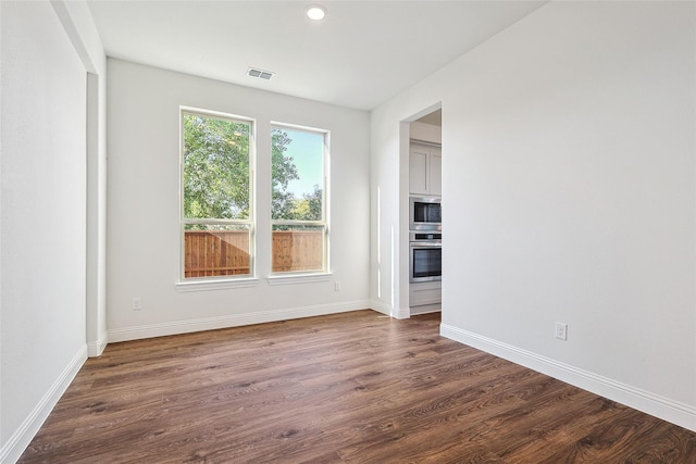 unfurnished room featuring dark wood-type flooring