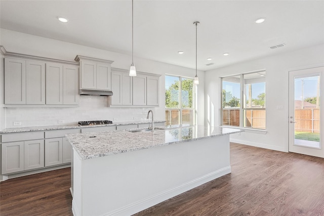 kitchen with gray cabinets, sink, stainless steel gas stovetop, and a kitchen island with sink