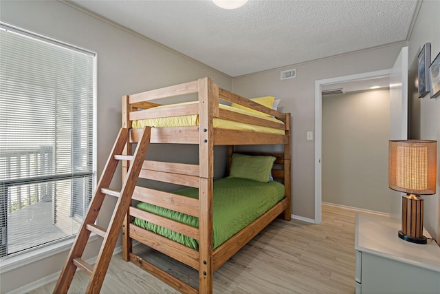 bedroom with a textured ceiling and light wood-type flooring