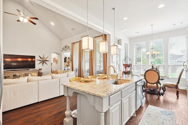 kitchen featuring decorative light fixtures, sink, a kitchen island with sink, light stone countertops, and a kitchen breakfast bar