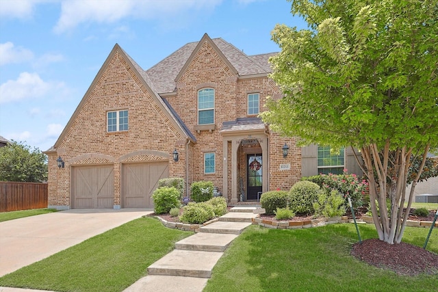 tudor-style house featuring a garage and a front lawn