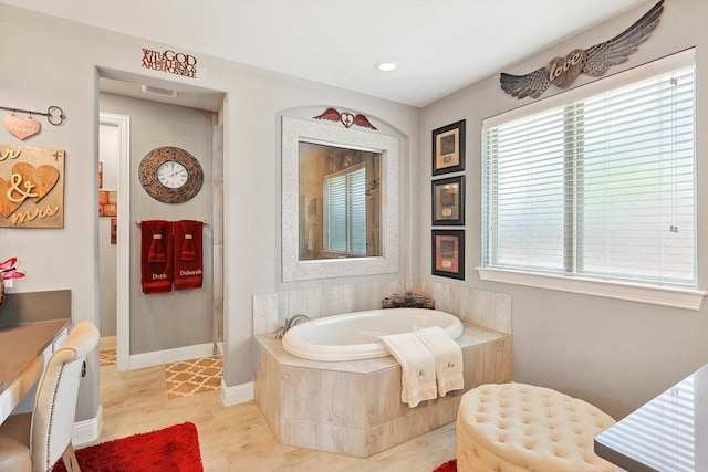 bathroom featuring a relaxing tiled tub