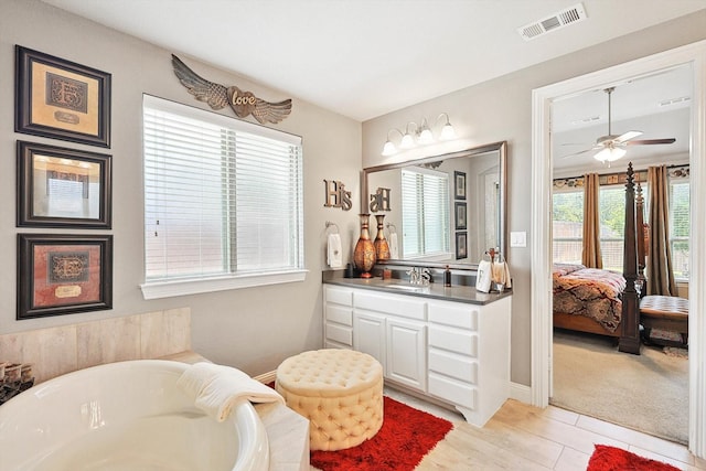 bathroom featuring a bathing tub, wood-type flooring, vanity, and ceiling fan