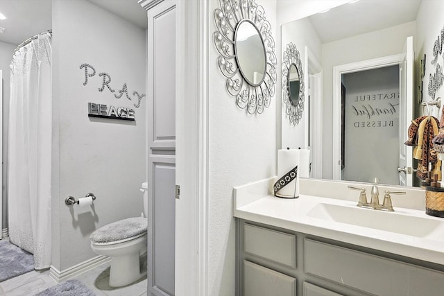 bathroom featuring toilet, vanity, and tile patterned flooring