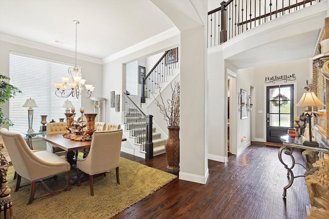 dining area with dark hardwood / wood-style floors, crown molding, and a notable chandelier