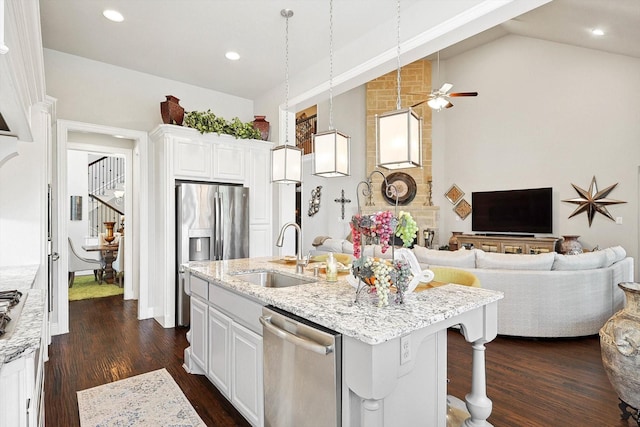 kitchen with pendant lighting, sink, an island with sink, stainless steel appliances, and white cabinets