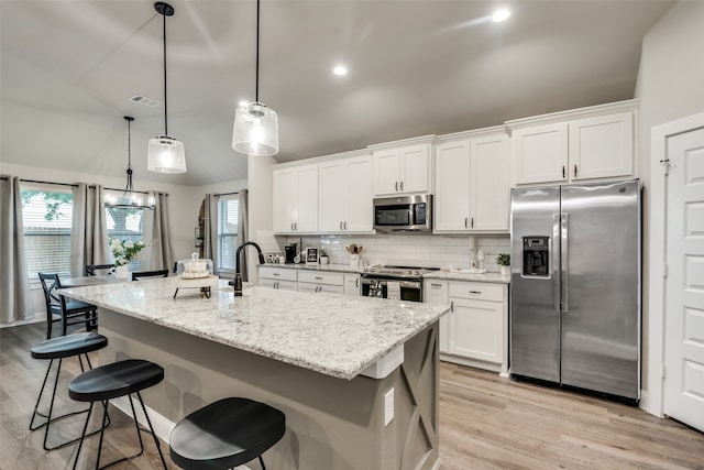 kitchen featuring white cabinets, stainless steel appliances, and light wood-type flooring