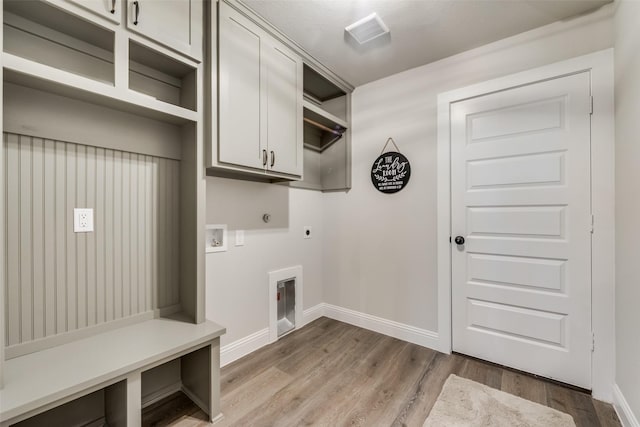 washroom with washer hookup, cabinets, hardwood / wood-style flooring, and electric dryer hookup