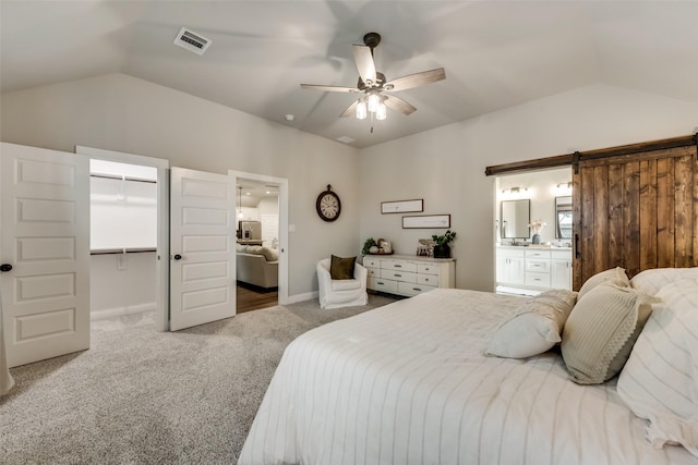 carpeted bedroom with a spacious closet, lofted ceiling, a closet, ceiling fan, and ensuite bathroom