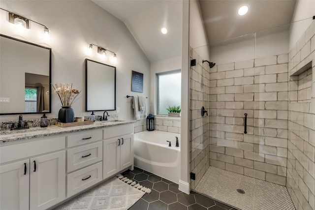 bathroom featuring lofted ceiling, vanity, independent shower and bath, and tile patterned floors