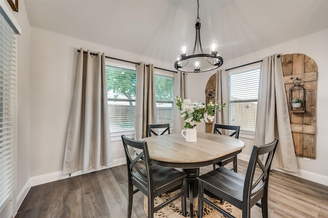 dining area with hardwood / wood-style flooring, a chandelier, and a healthy amount of sunlight