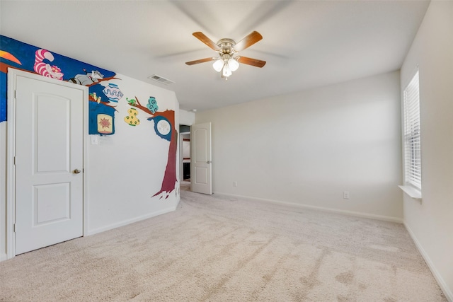 carpeted spare room with ceiling fan