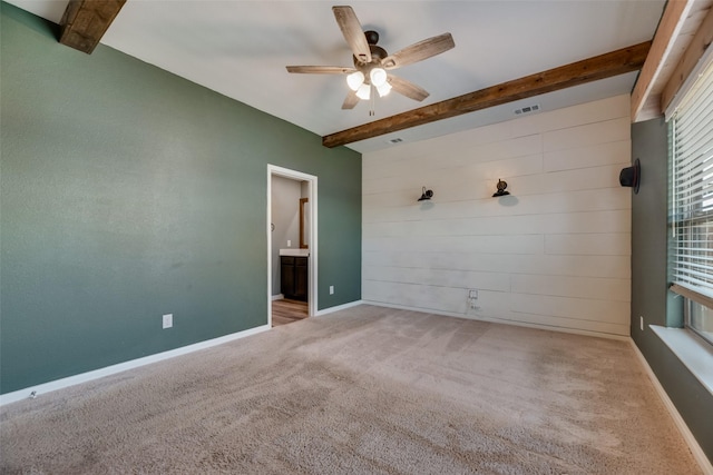 carpeted empty room with ceiling fan and beam ceiling