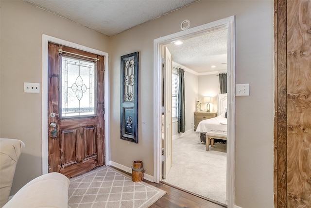 carpeted entryway featuring a textured ceiling