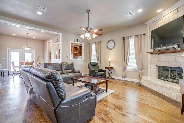 living room featuring plenty of natural light, a fireplace, hardwood / wood-style floors, and ceiling fan