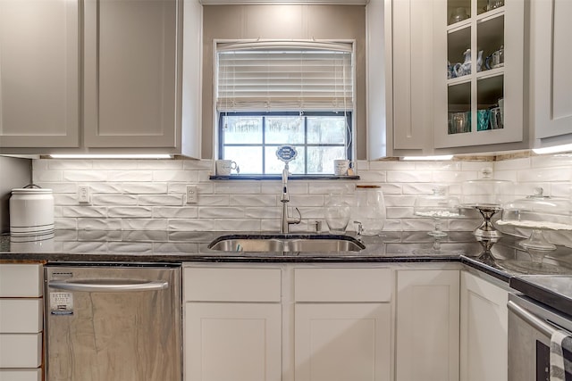 kitchen with white cabinets, dark stone counters, and stainless steel dishwasher