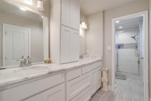 bathroom with dual vanity, an enclosed shower, and tile patterned floors