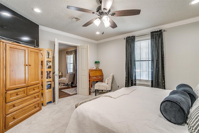 bedroom with a textured ceiling, crown molding, carpet floors, and ceiling fan