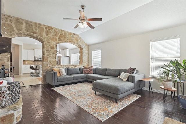 living room featuring ceiling fan, plenty of natural light, dark hardwood / wood-style floors, and vaulted ceiling