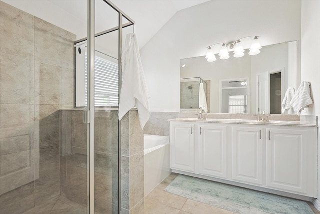 bathroom with tile patterned floors, vaulted ceiling, independent shower and bath, and vanity