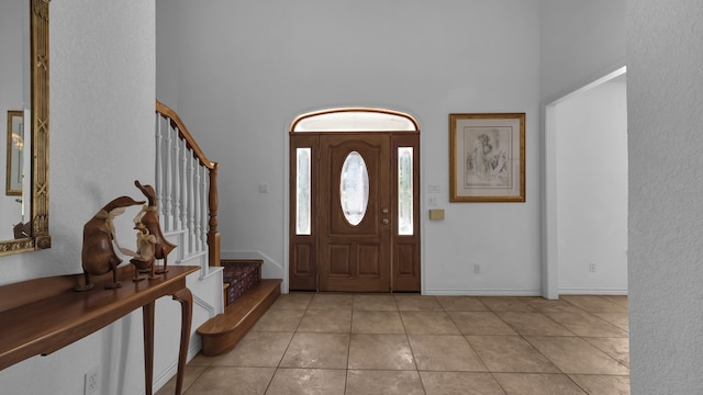 tiled foyer entrance featuring a towering ceiling