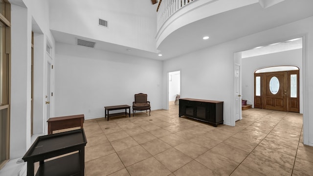 entrance foyer with light tile patterned floors and a high ceiling