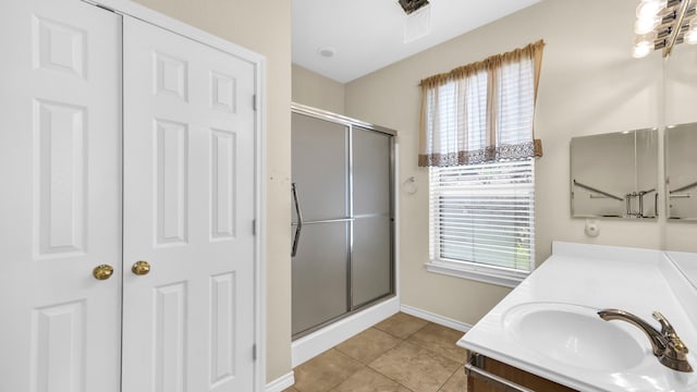 bathroom with tile patterned flooring, vanity, and walk in shower