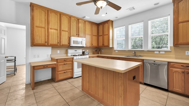 kitchen featuring a center island, light tile patterned floors, white appliances, and sink