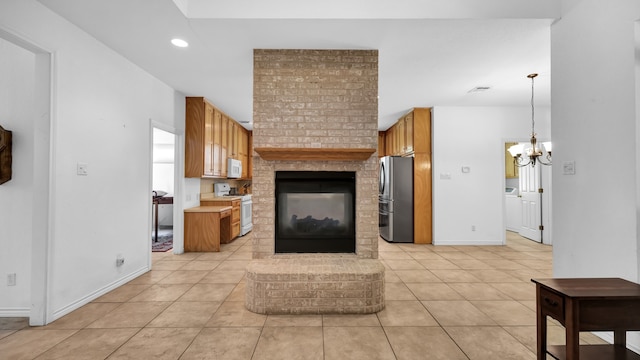 kitchen with white appliances, light tile patterned floors, a fireplace, decorative light fixtures, and a chandelier