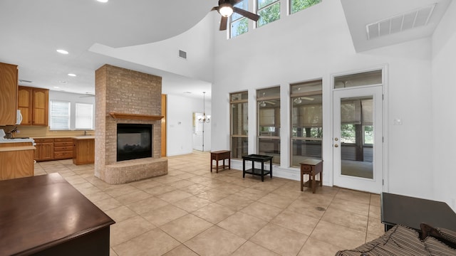 living room with a fireplace, ceiling fan, and light tile patterned flooring