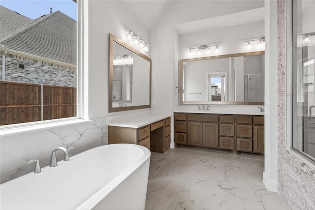 bathroom with tile patterned flooring, a washtub, vaulted ceiling, and vanity