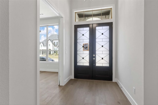 foyer entrance with french doors and hardwood / wood-style floors