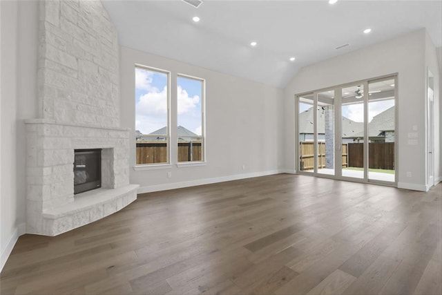 unfurnished living room featuring dark hardwood / wood-style floors, vaulted ceiling, and a fireplace