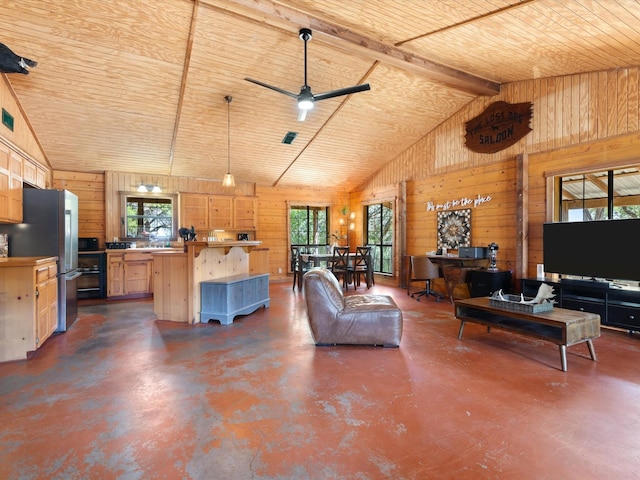 living room with plenty of natural light, ceiling fan, and wooden walls