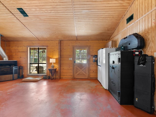 miscellaneous room with wood walls, a healthy amount of sunlight, concrete flooring, and wooden ceiling