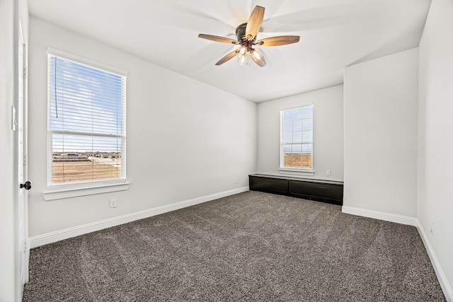 unfurnished room featuring ceiling fan and dark colored carpet