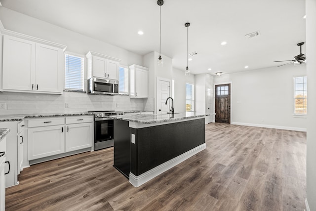 kitchen with an island with sink, hardwood / wood-style flooring, white cabinetry, and dishwasher