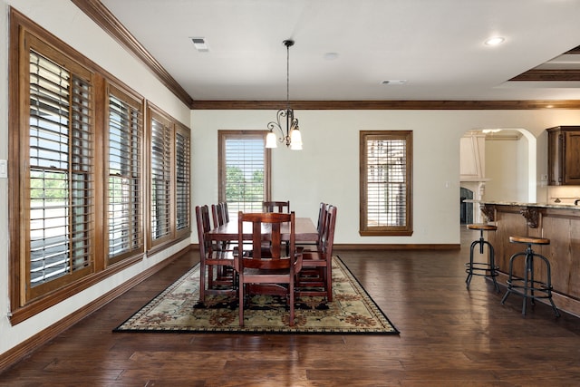 dining room featuring a wealth of natural light, crown molding, dark hardwood / wood-style floors, and an inviting chandelier