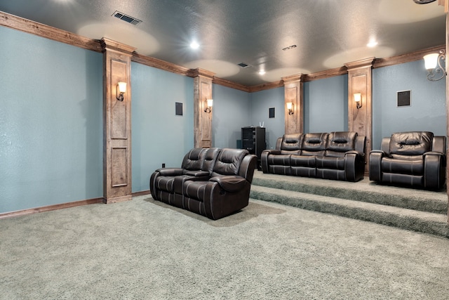 home theater room featuring carpet flooring, crown molding, and decorative columns